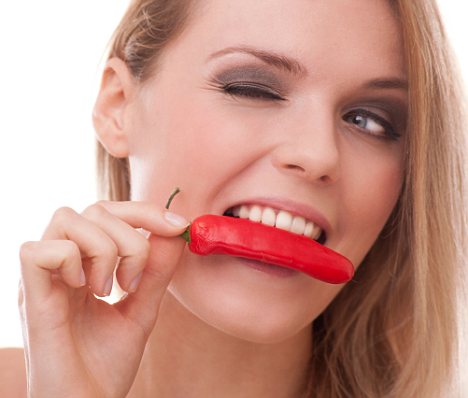 woman biting into a hot red chilli / photo from http://www.dailymail.co.uk